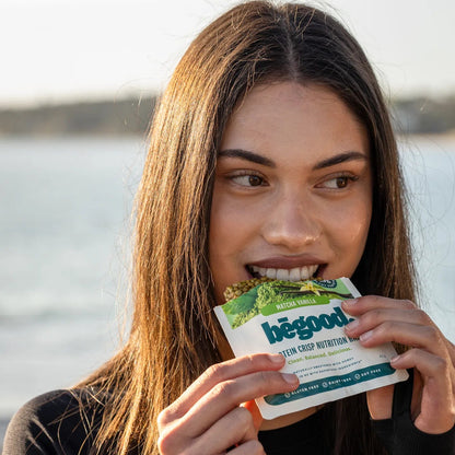 Woman holding a 'begood' product by a body of water