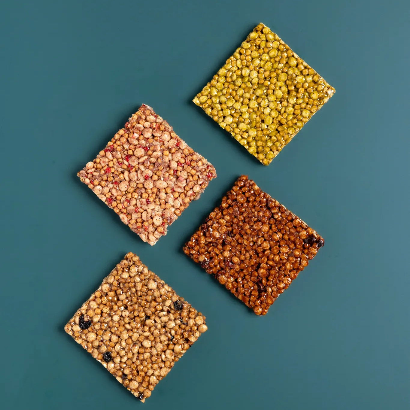 Four bēgood nutrition protein bars showing different types of grains on a teal background