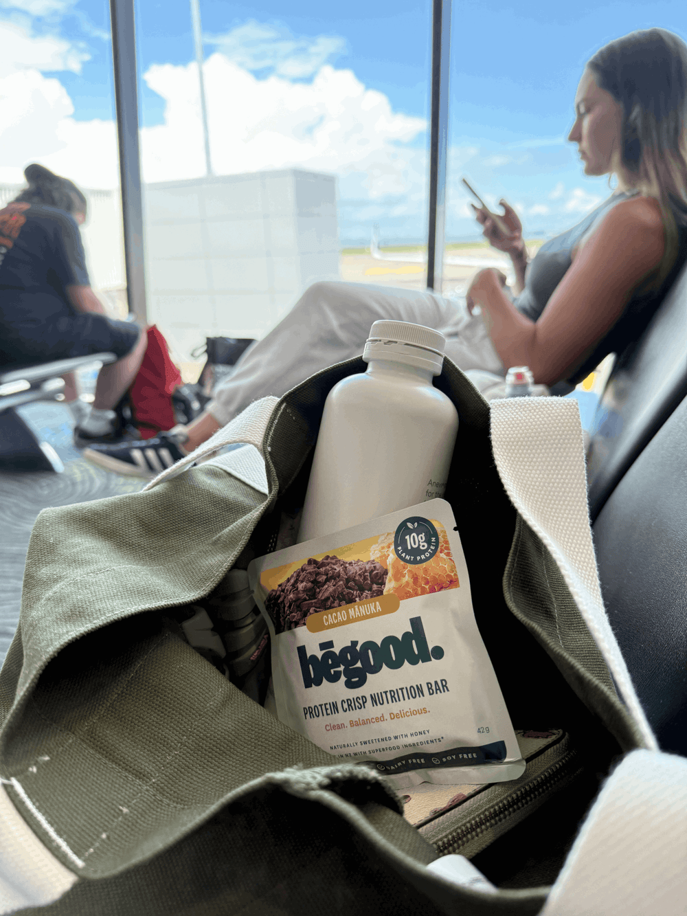 Protein bar and bottle in a bag with people in the background